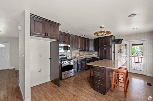 6871 S Alfalfa Cir, West Jordan, UT 84084 - kitchen featuring stainless steel appliances, wood finished floors, and dark brown cabinets