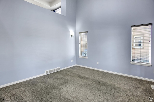 888 N Shepard Creek Pkwy W, Farmington, UT 84025 - empty room featuring dark colored carpet, a towering ceiling, and healthy amount of natural light