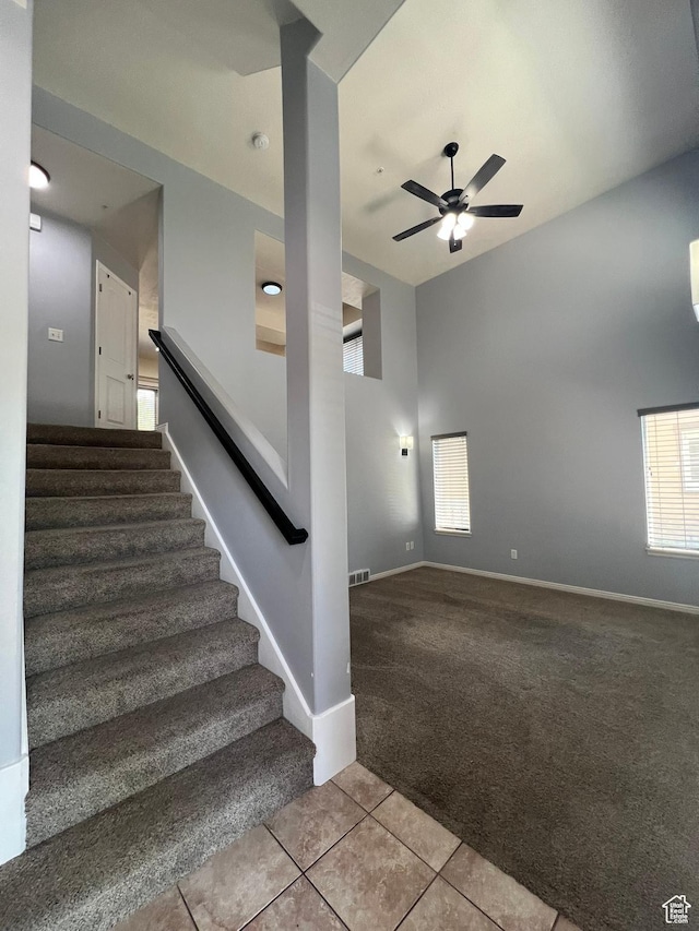 888 N Shepard Creek Pkwy W, Farmington, UT 84025 - stairway featuring carpet flooring, tile patterned flooring, a ceiling fan, and a towering ceiling