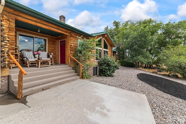 986 E 2290 N, Monroe, UT 84754 - entrance to property featuring log siding, a chimney, and covered porch