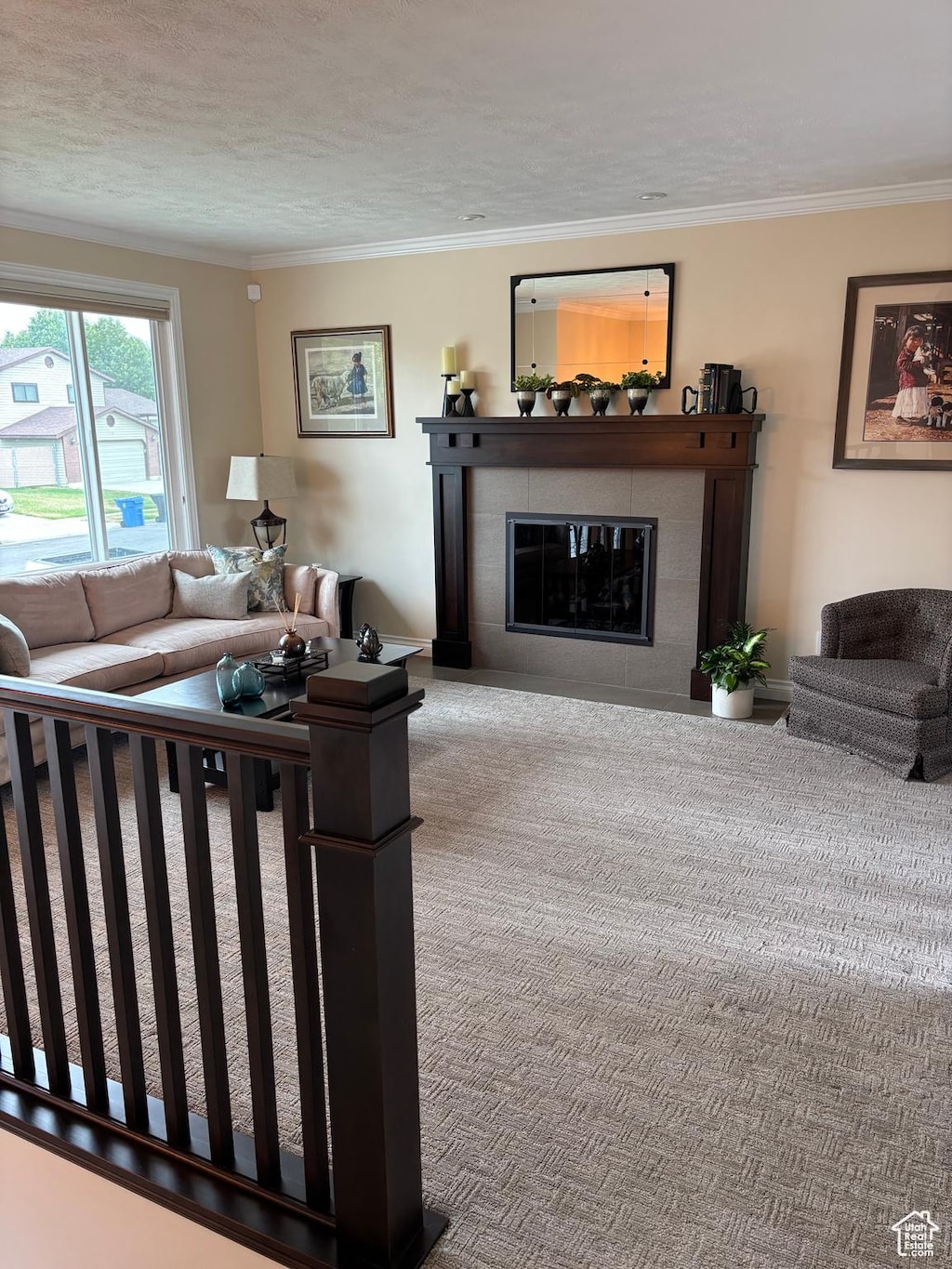 2165 W Tierra Rose Dr, Taylorsville, UT 84129 - carpeted living area featuring a fireplace and crown molding
