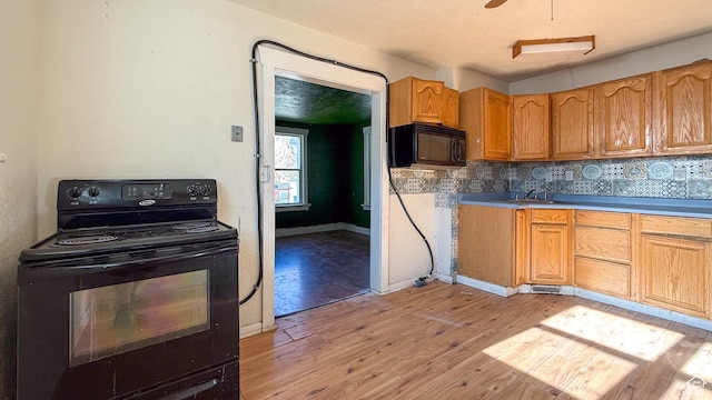 347 Hill St, Helper, UT 84526 - kitchen featuring black appliances, light wood finished floors, tasteful backsplash, and brown cabinets