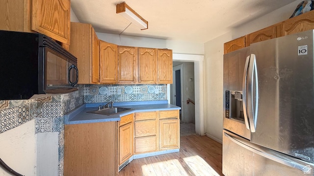 347 Hill St, Helper, UT 84526 - kitchen with stainless steel refrigerator with ice dispenser, black microwave, light wood-style flooring, light countertops, and decorative backsplash