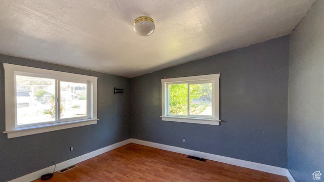 347 Hill St, Helper, UT 84526 - empty room with vaulted ceiling, wood finished floors, and a textured ceiling