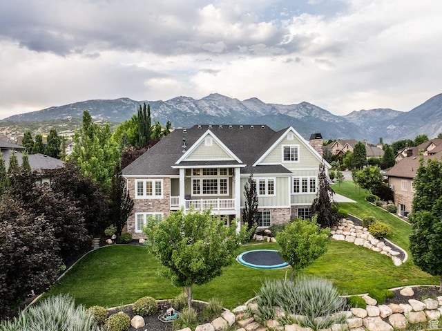 5843 W Wildflower Ln, Highland, UT 84003 - back of property with stone siding, a mountain view, a chimney, and a yard