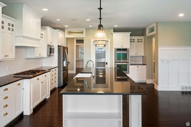 5843 W Wildflower Ln, Highland, UT 84003 - kitchen featuring stainless steel appliances, dark countertops, dark wood-type flooring, a kitchen island with sink, and recessed lighting