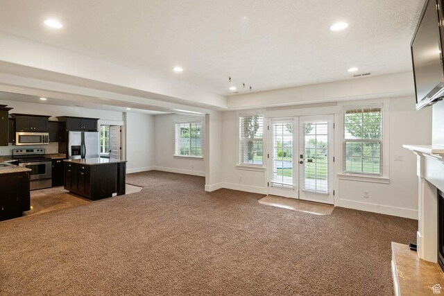 5843 W Wildflower Ln, Highland, UT 84003 - unfurnished living room with french doors, carpet floors, recessed lighting, plenty of natural light, and a high end fireplace