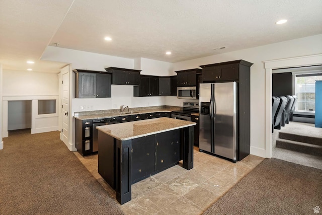 5843 W Wildflower Ln, Highland, UT 84003 - kitchen featuring stainless steel appliances, dark cabinets, a kitchen island, recessed lighting, and light carpet