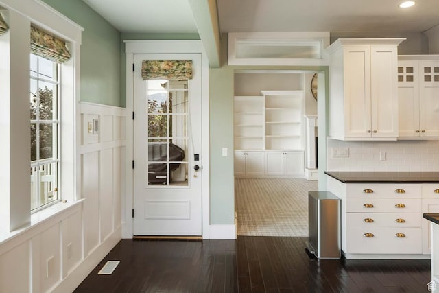 5843 W Wildflower Ln, Highland, UT 84003 - kitchen with dark countertops, white cabinetry, dark wood-type flooring, a decorative wall, and wainscoting