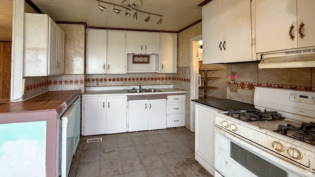 127 Grassy Dr, East Carbon, UT 84520 - kitchen with white gas stove, under cabinet range hood, decorative backsplash, light tile patterned flooring, and light countertops