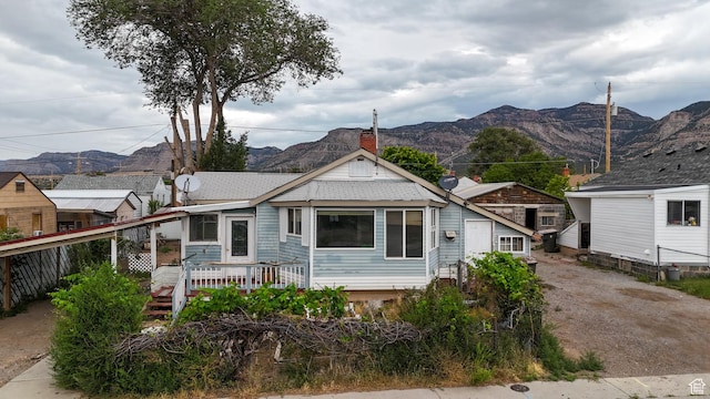 127 Grassy Dr, East Carbon, UT 84520 - view of front of property with a deck with mountain view, roof with shingles, and a chimney