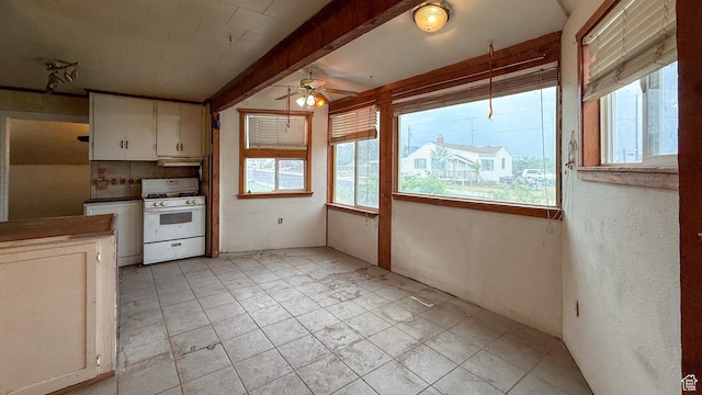 127 Grassy Dr, East Carbon, UT 84520 - kitchen with white range with gas stovetop, ceiling fan, white cabinetry, and under cabinet range hood