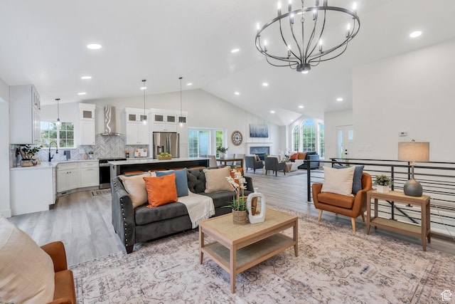 12060 S Lampton Dr W, Riverton, UT 84065 - living room featuring light wood finished floors, healthy amount of natural light, a chandelier, recessed lighting, and a fireplace
