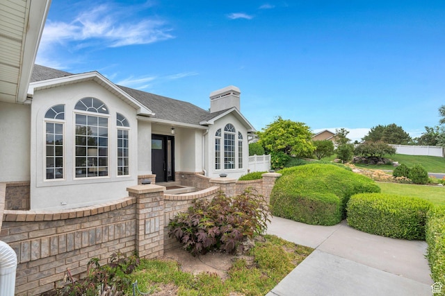 12060 S Lampton Dr W, Riverton, UT 84065 - doorway to property featuring stucco siding, a chimney, and roof with shingles