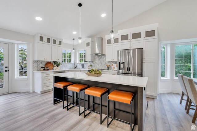 12060 S Lampton Dr W, Riverton, UT 84065 - kitchen featuring stainless steel fridge, wall chimney exhaust hood, a center island, decorative backsplash, and lofted ceiling
