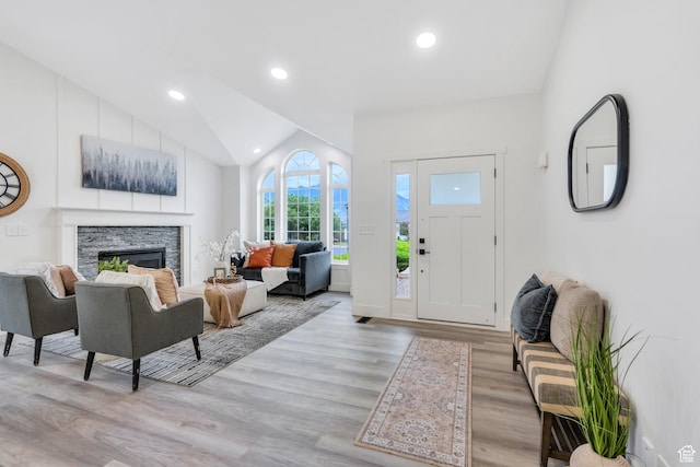 12060 S Lampton Dr W, Riverton, UT 84065 - foyer entrance with light wood-style flooring, vaulted ceiling, a stone fireplace, and recessed lighting