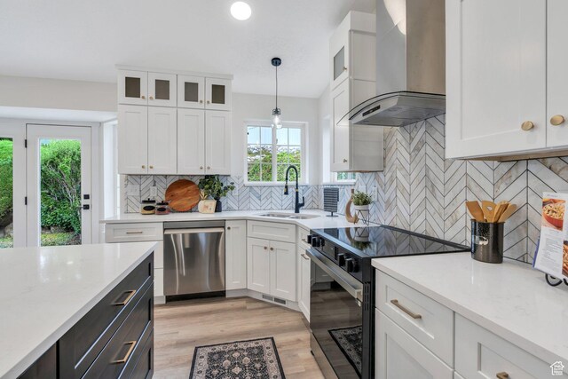 12060 S Lampton Dr W, Riverton, UT 84065 - kitchen with wall chimney range hood, dishwasher, black electric range oven, white cabinetry, and decorative light fixtures