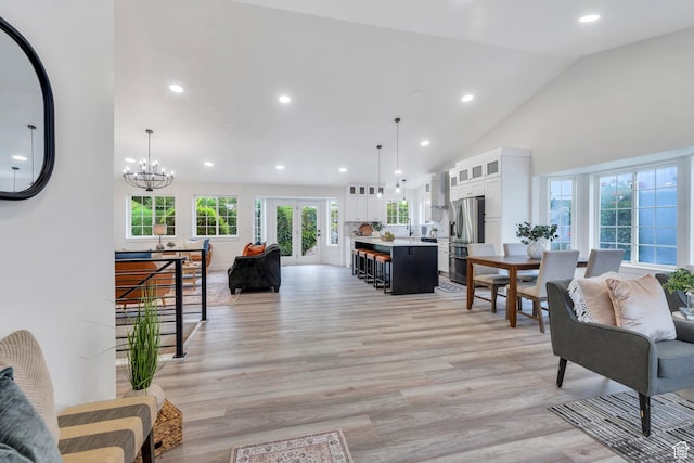 12060 S Lampton Dr W, Riverton, UT 84065 - living room with light wood-type flooring, recessed lighting, high vaulted ceiling, and a chandelier