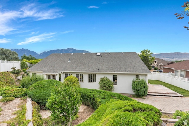 12060 S Lampton Dr W, Riverton, UT 84065 - back of house featuring stucco siding, a deck with mountain view, roof with shingles, and a patio