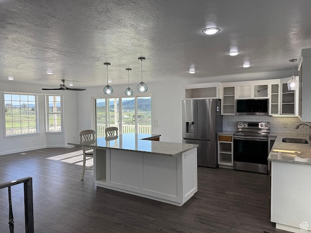 34840 N 10265 E, Fairview, UT 84629 - kitchen with appliances with stainless steel finishes, a textured ceiling, dark wood finished floors, tasteful backsplash, and a center island