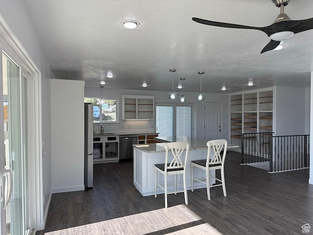 34840 N 10265 E, Fairview, UT 84629 - kitchen with appliances with stainless steel finishes, a center island, tasteful backsplash, dark wood-type flooring, and a textured ceiling