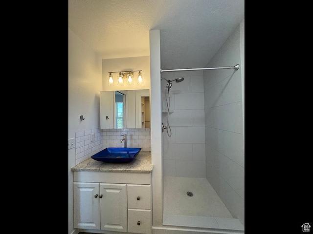34840 N 10265 E, Fairview, UT 84629 - bathroom featuring a tile shower, vanity, backsplash, and a textured ceiling