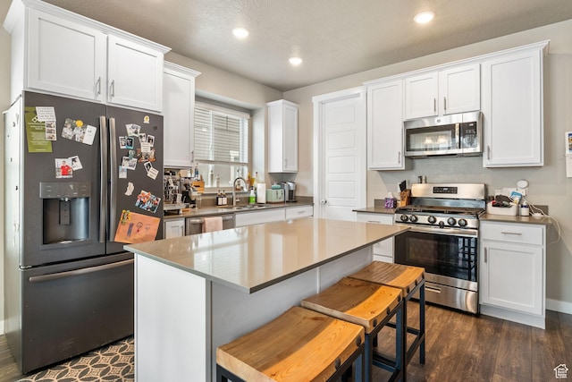 2319 N Penstemon Way, Lehi, UT 84043 - kitchen with appliances with stainless steel finishes, white cabinetry, recessed lighting, a center island, and dark wood finished floors