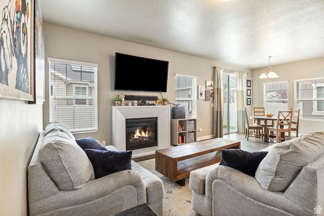 2319 N Penstemon Way, Lehi, UT 84043 - living room featuring a glass covered fireplace, a textured ceiling, and wood finished floors