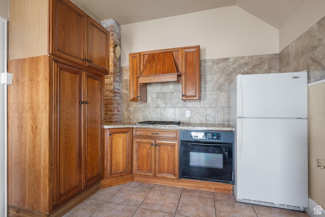 1145 Kensington Ave, Salt Lake City, UT 84105 - kitchen featuring freestanding refrigerator, black oven, custom range hood, brown cabinets, and vaulted ceiling