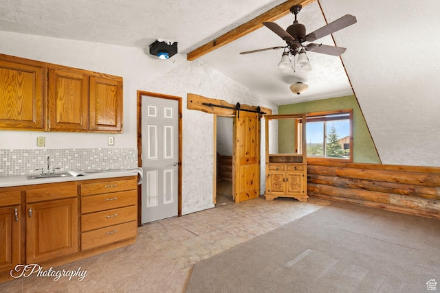 503 S Cottonwood Dr, Brookside, UT 84782 - kitchen featuring a barn door, brown cabinets, light countertops, ceiling fan, and decorative backsplash