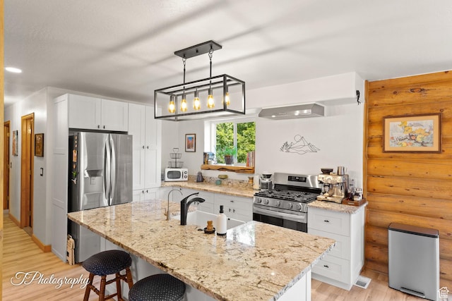 503 S Cottonwood Dr, Brookside, UT 84782 - kitchen featuring stainless steel appliances, light wood-style floors, white cabinetry, a kitchen bar, and light stone counters