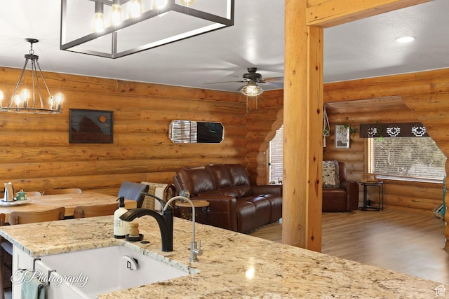 503 S Cottonwood Dr, Brookside, UT 84782 - kitchen with a chandelier, rustic walls, open floor plan, wood finished floors, and light stone countertops