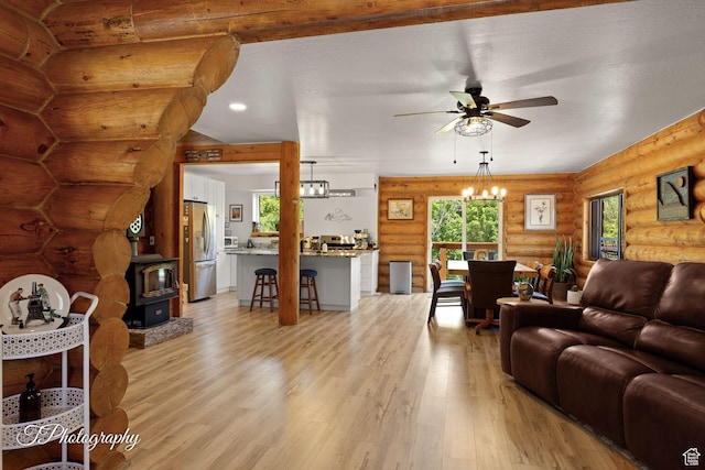 503 S Cottonwood Dr, Brookside, UT 84782 - living room with ceiling fan, light wood-type flooring, log walls, a wood stove, and a chandelier