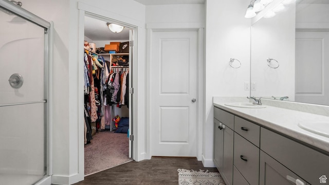 5681 W Pelican Ridge Ln, Salt Lake City, UT 84118 - full bathroom with a stall shower, a spacious closet, double vanity, and wood finished floors