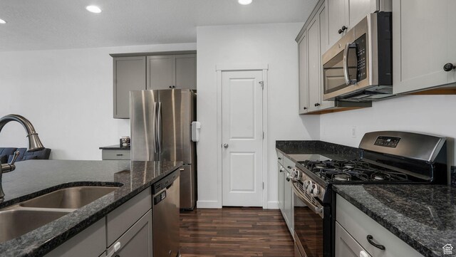 5681 W Pelican Ridge Ln, Salt Lake City, UT 84118 - kitchen with appliances with stainless steel finishes, gray cabinets, dark wood finished floors, recessed lighting, and dark stone counters