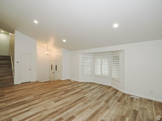 9971 S Borg Dr, Sandy, UT 84092 - unfurnished living room featuring a chandelier, stairway, light wood-style flooring, recessed lighting, and lofted ceiling
