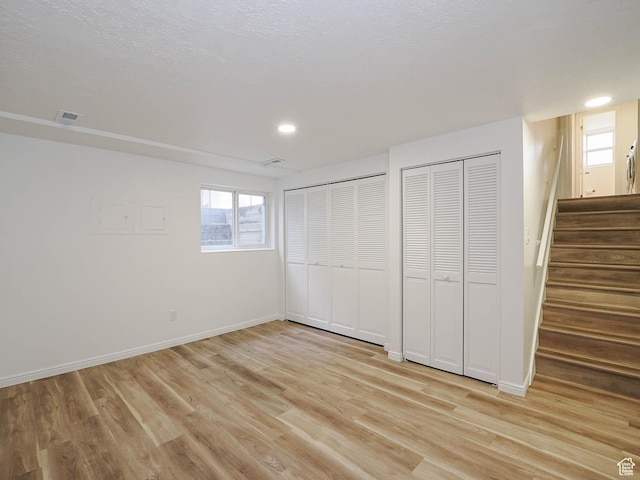 9971 S Borg Dr, Sandy, UT 84092 - unfurnished bedroom with light wood-style flooring, two closets, multiple windows, and recessed lighting