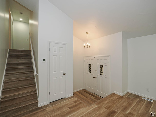 9971 S Borg Dr, Sandy, UT 84092 - entryway with wood finished floors, stairway, lofted ceiling, and a chandelier