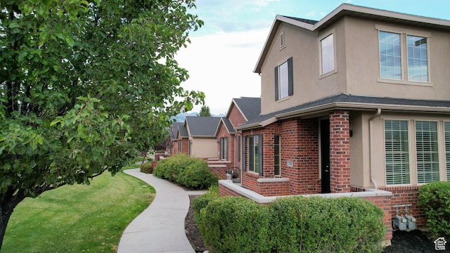 144 W 3430 N, Lehi, UT 84043 - view of side of property with brick siding, stucco siding, and a lawn