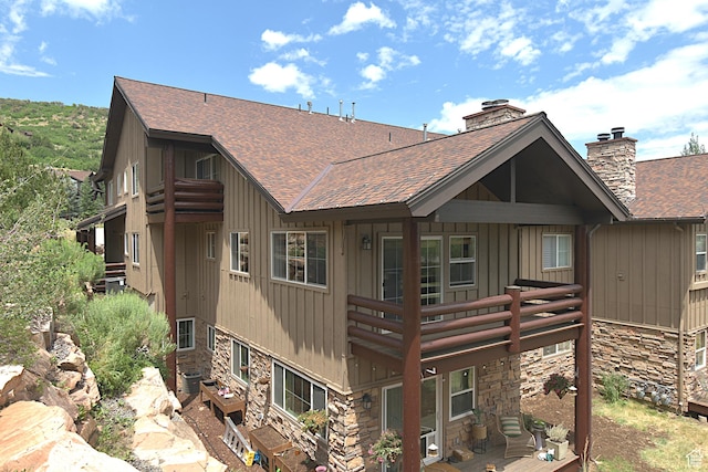 5133 N Cove Canyon Dr Unit 200, Park City, UT 84098 - rear view of house with a shingled roof, stone siding, a chimney, and board and batten siding