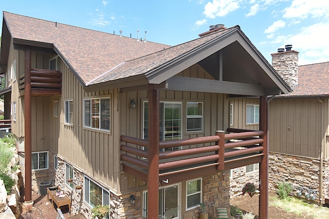 5133 N Cove Canyon Dr Unit 200, Park City, UT 84098 - back of property featuring stone siding, a shingled roof, board and batten siding, and a chimney