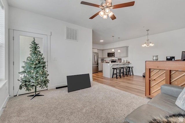1382 N 3650 W Unit V101, Lehi, UT 84043 - living room featuring ceiling fan, a chandelier, light wood finished floors, and light colored carpet