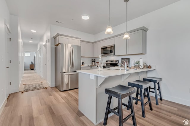 1382 N 3650 W Unit V101, Lehi, UT 84043 - kitchen featuring stainless steel appliances, a peninsula, light wood-style floors, a kitchen bar, and recessed lighting