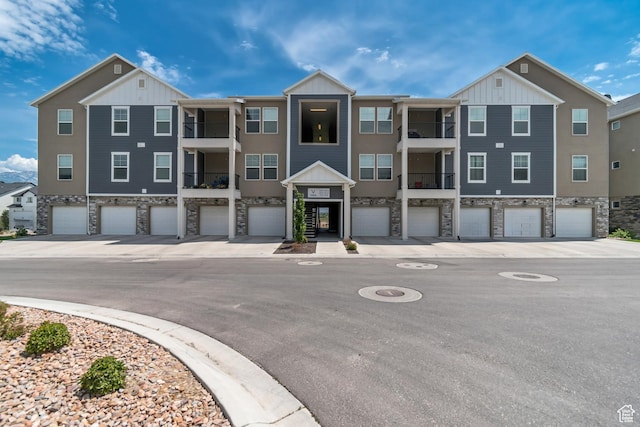 1382 N 3650 W Unit V101, Lehi, UT 84043 - view of front facade with stone siding, an attached garage, and board and batten siding