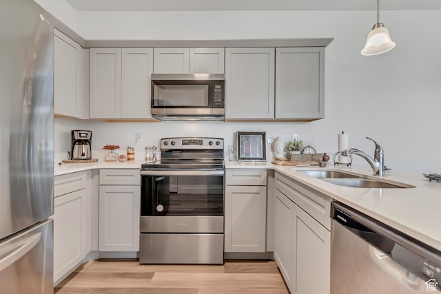 1382 N 3650 W Unit V101, Lehi, UT 84043 - kitchen with stainless steel appliances, light countertops, light wood-style floors, gray cabinets, and pendant lighting