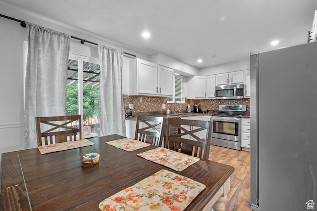 3305 W Kingsbrook Ave S Unit 148, Taylorsville, UT 84129 - kitchen with appliances with stainless steel finishes, healthy amount of natural light, white cabinetry, backsplash, and recessed lighting