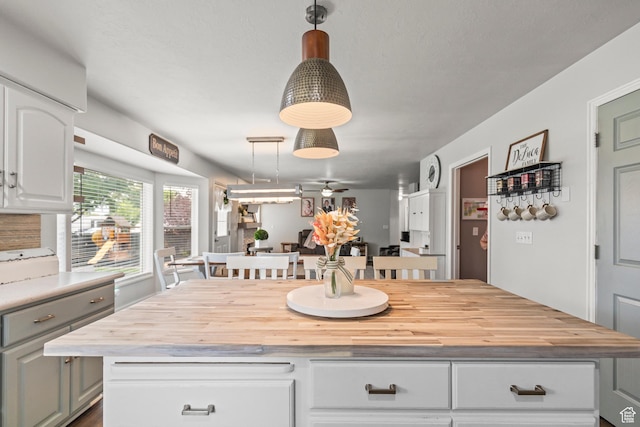 528 W 650 S, Richfield, UT 84701 - kitchen with wooden counters, white cabinets, a ceiling fan, a kitchen island, and hanging light fixtures