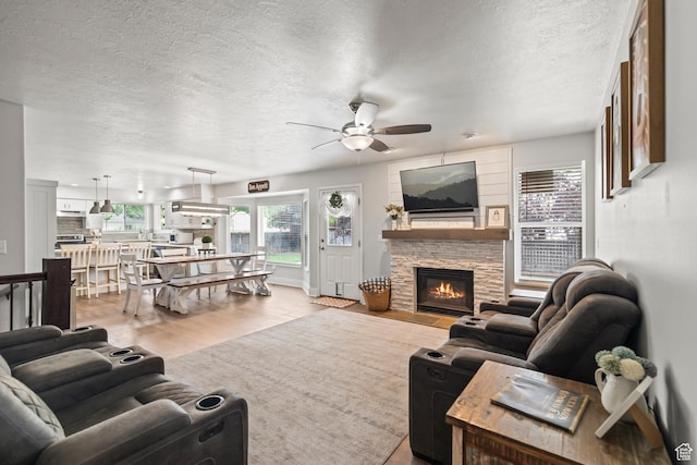 528 W 650 S, Richfield, UT 84701 - living room with ceiling fan, a textured ceiling, wood finished floors, and a stone fireplace
