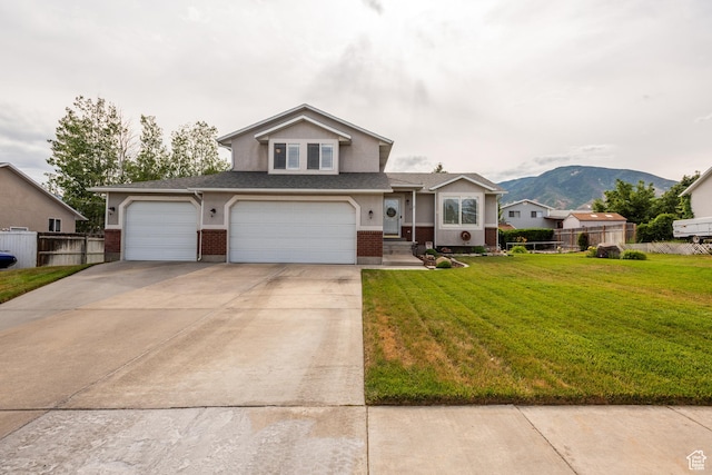 576 Mayo Dr N, Tooele, UT 84074 - view of front of home with brick siding, driveway, a mountain view, an attached garage, and roof with shingles