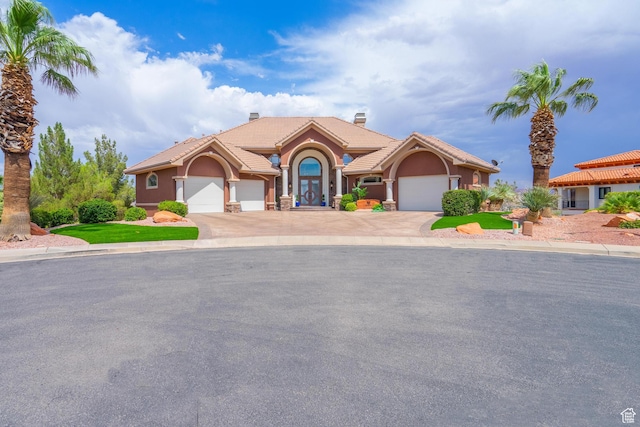 16 N Lions Head Cir, Washington, UT 84780 - mediterranean / spanish-style house with stucco siding, a tiled roof, a garage, a chimney, and driveway